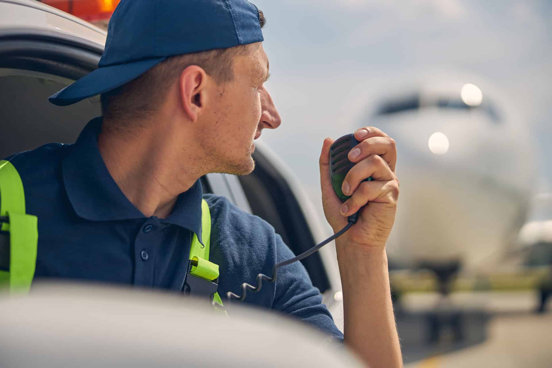 Close up portrait of a professional ground vehicle operator with a microphone in his hand looking away