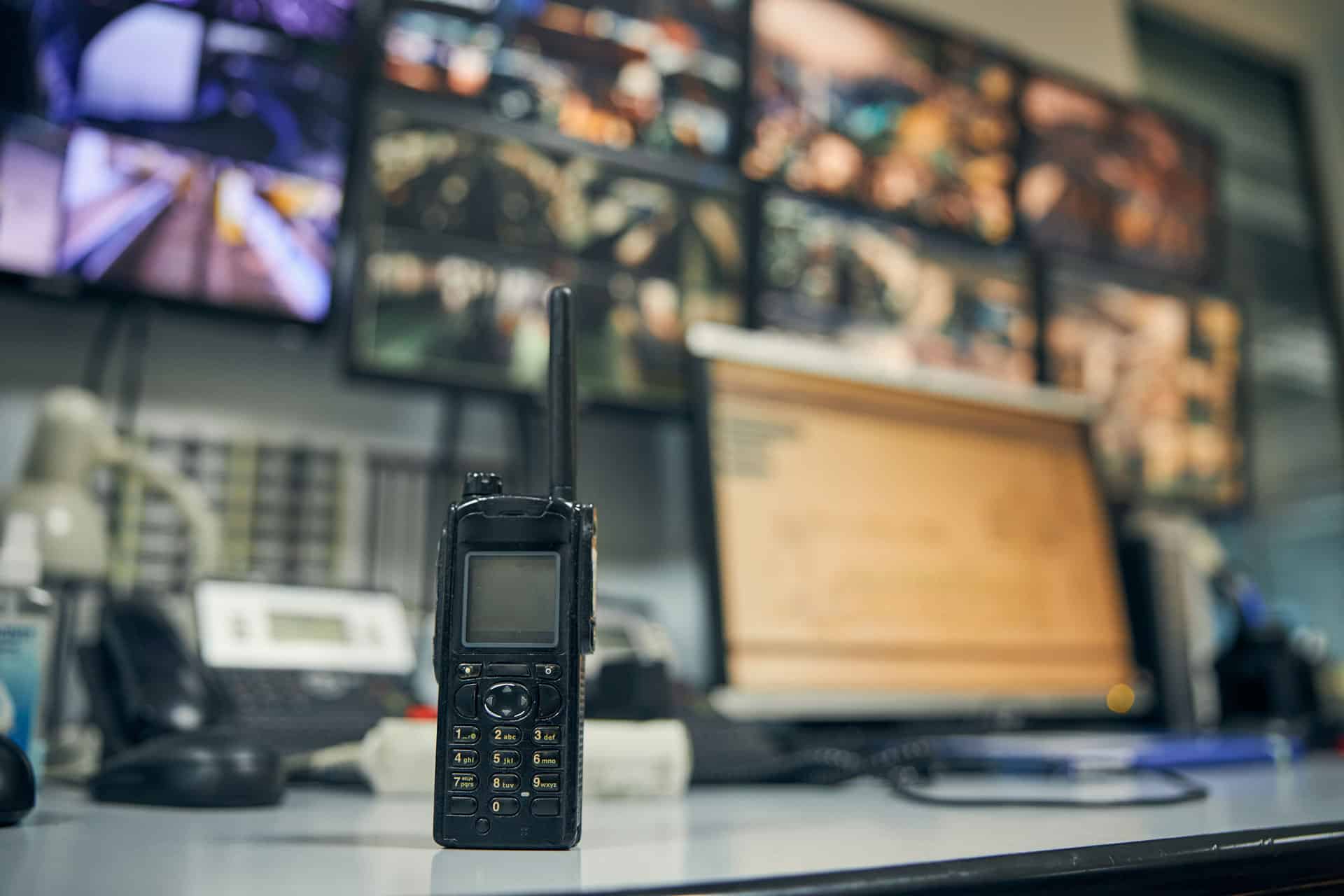 Close-up photo of a walkie-talkie sitting on an office desk in a security control room